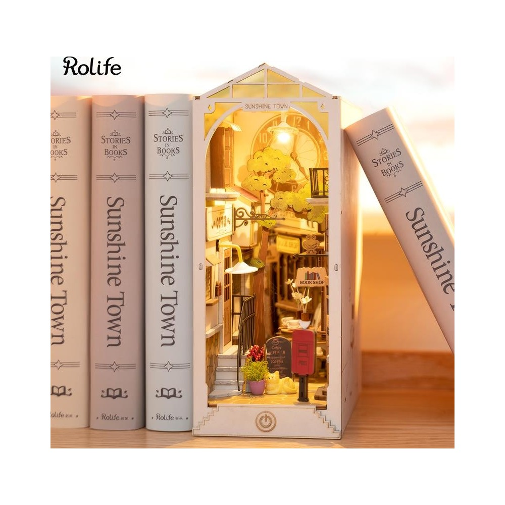 Kitap köşesi, binalar ve sokak lambası içeren minyatür bir sokak sahnesi sunar.