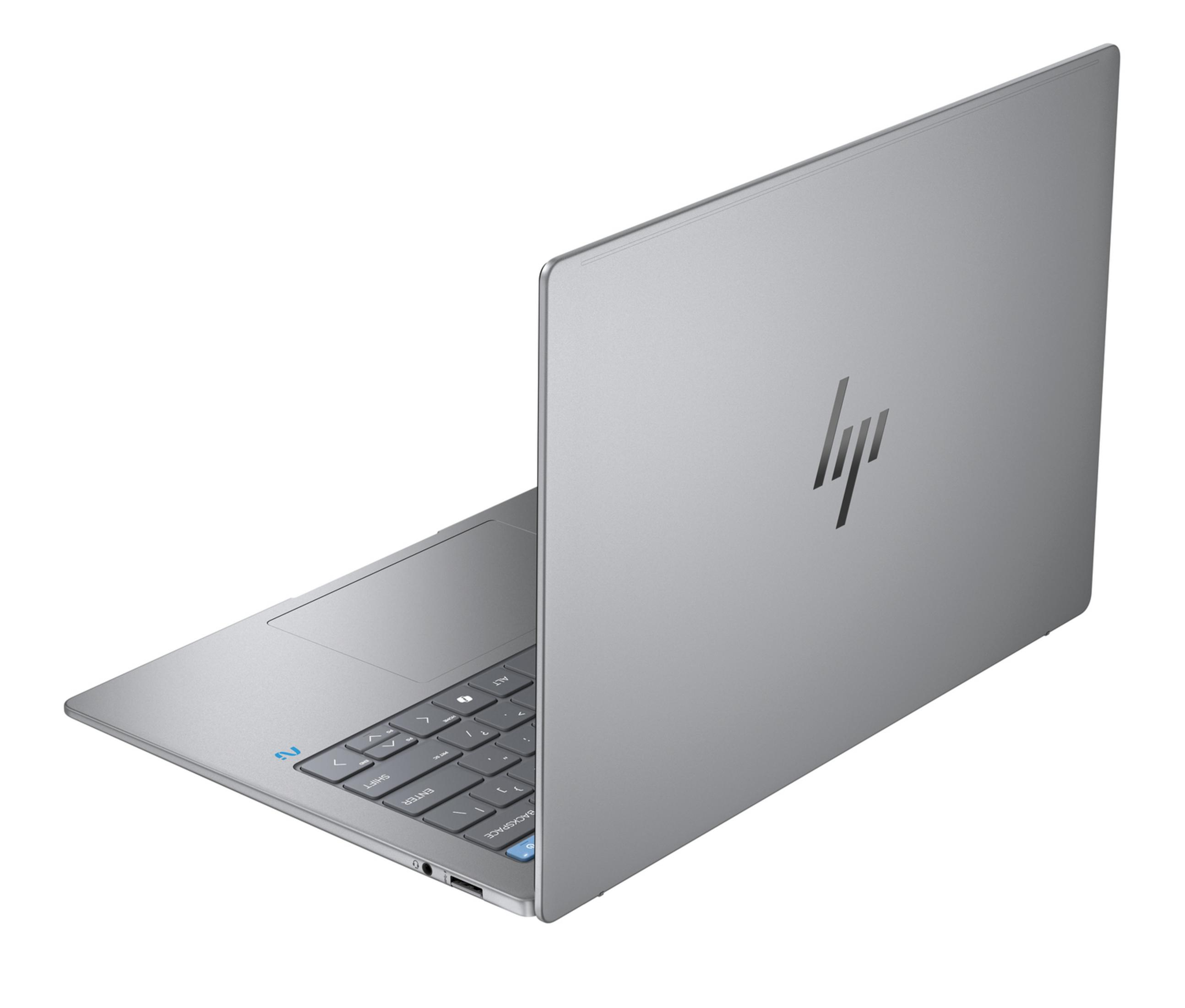 Un portátil HP plateado está abierto, mostrando el teclado y el logo en la tapa.