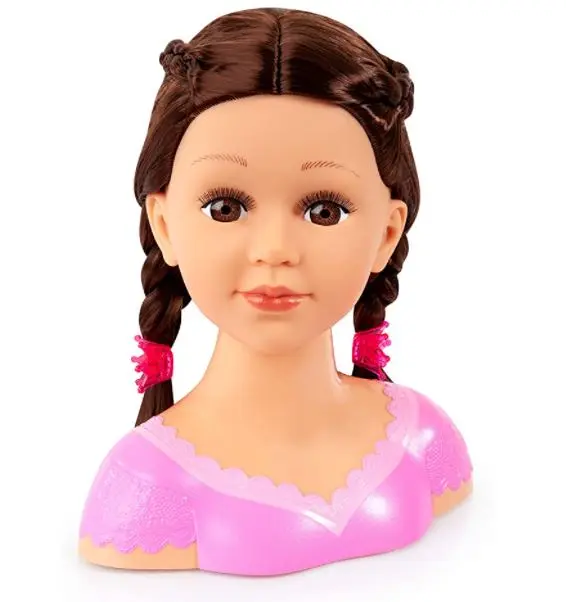Eine braunhaarige Puppe mit Zöpfen trägt ein rosa Kleid. Weiße Hintergrund.
