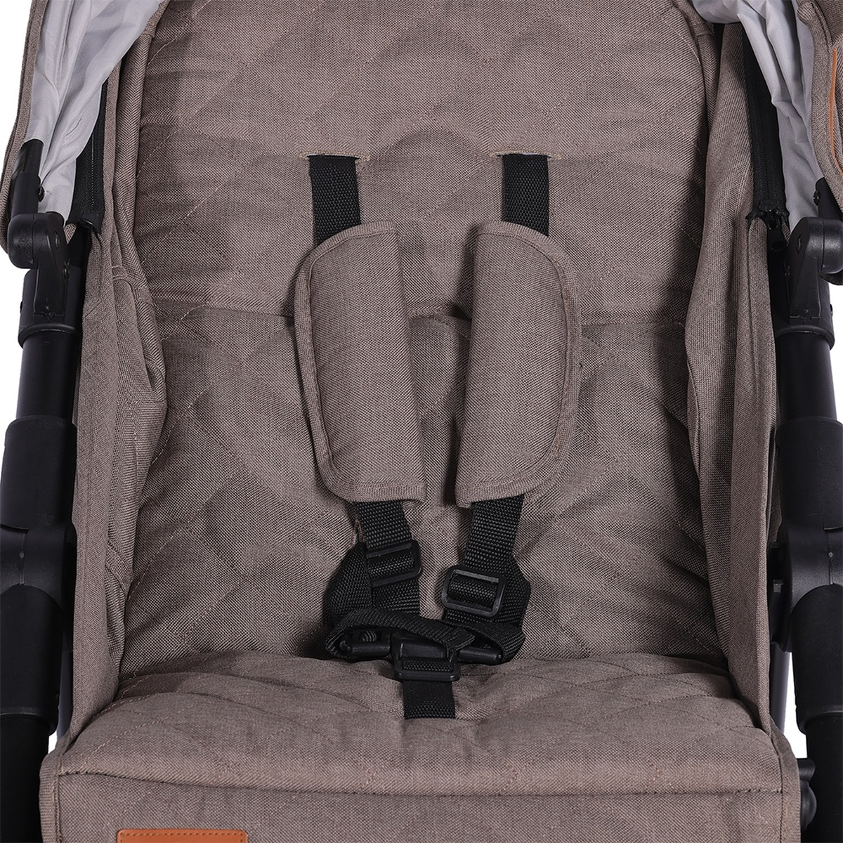 Nahaufnahme eines braunen, gesteppten Kinderwagensitzes mit schwarzen Gurten und Polsterungen.