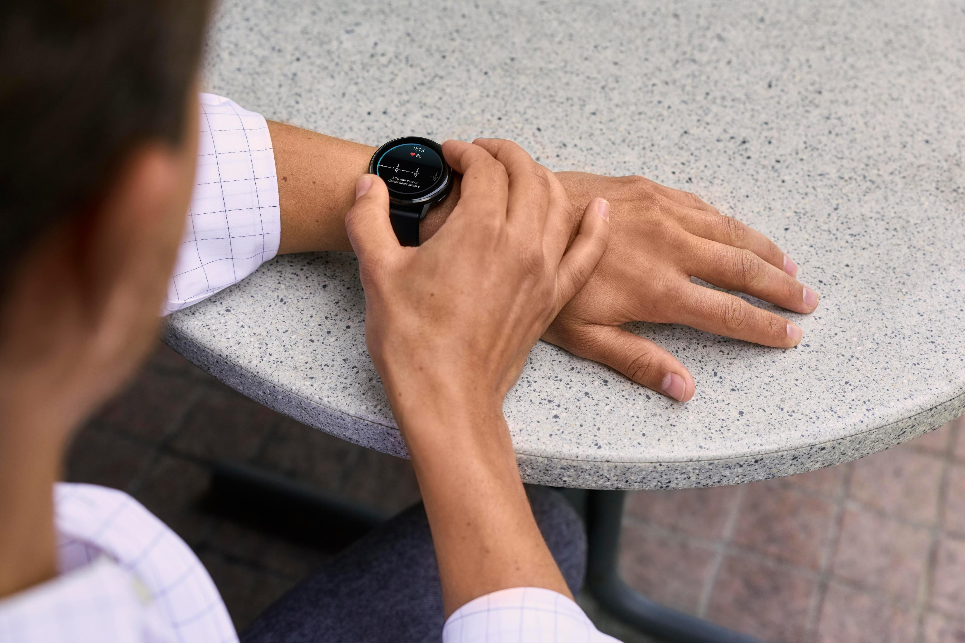 Primo piano del polso di un uomo con uno smartwatch che mostra un ECG.