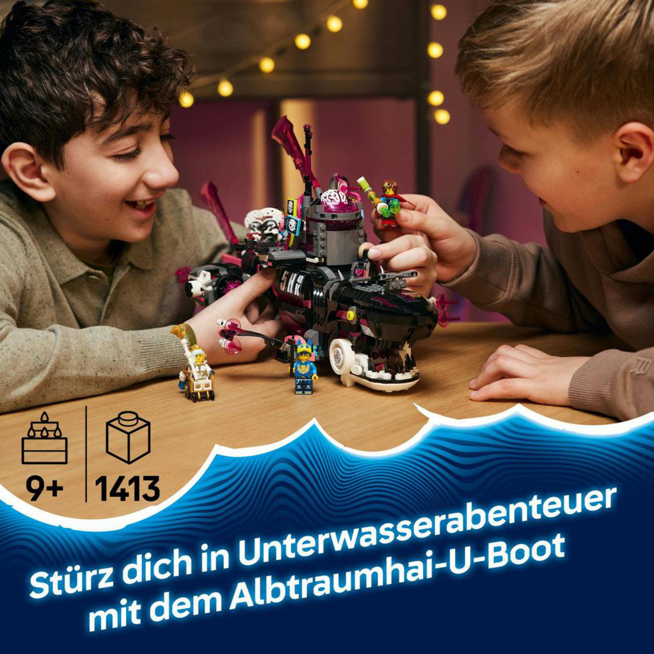 Dos niños construyen un submarino Lego con forma de tiburón.