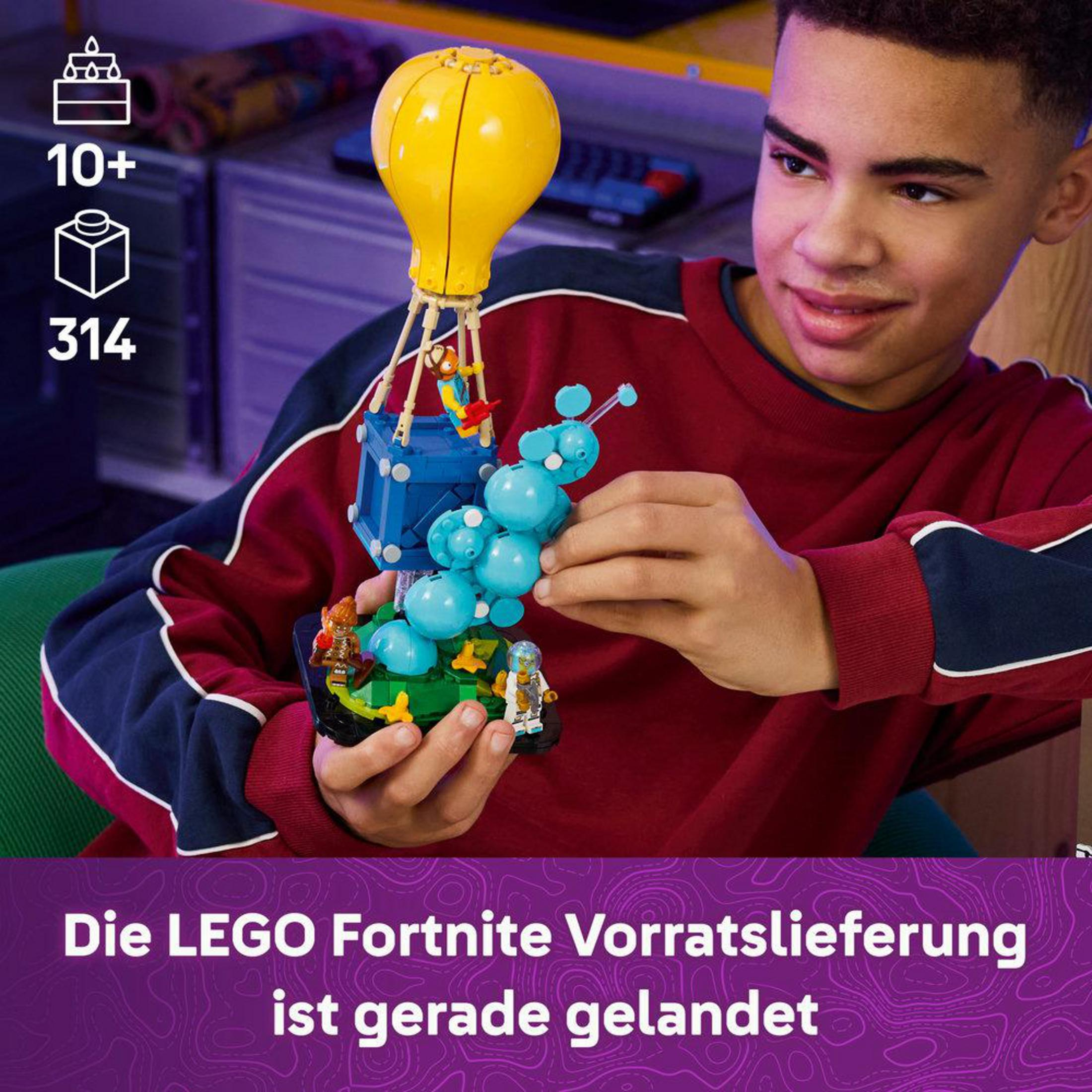 Un ragazzo tiene un set LEGO Fortnite con mongolfiera e personaggi.