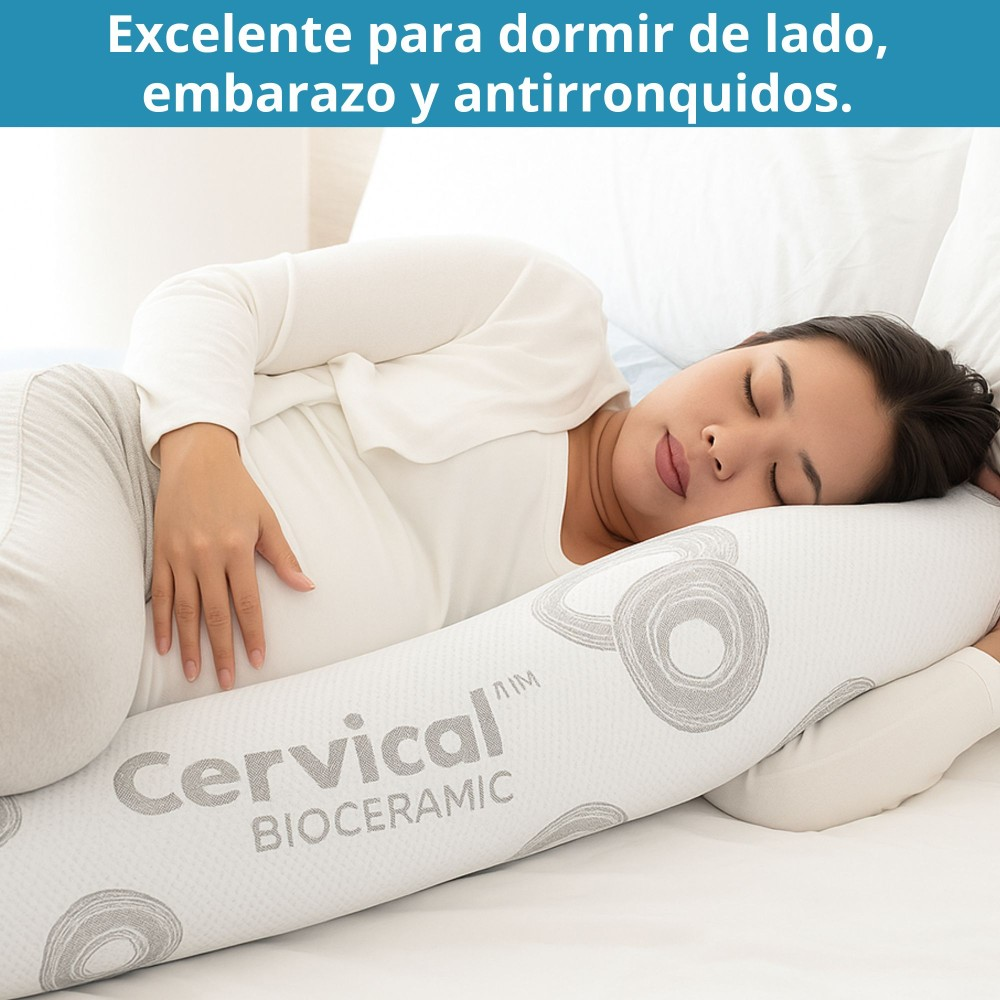 Una mujer duerme de lado, abrazando una almohada cervical larga y blanca con círculos grises.