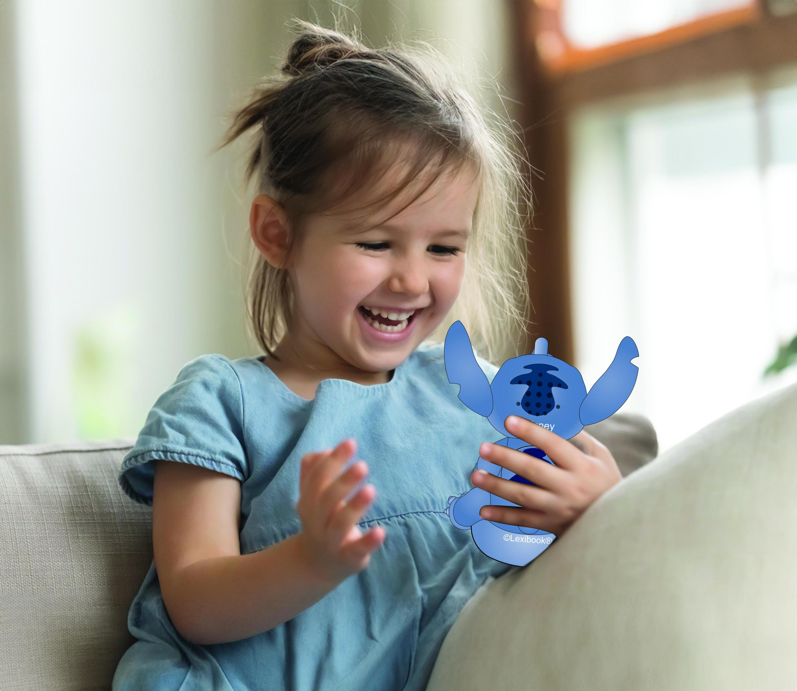 Una bambina sorridente in abito blu tiene un giocattolo blu di Stitch.