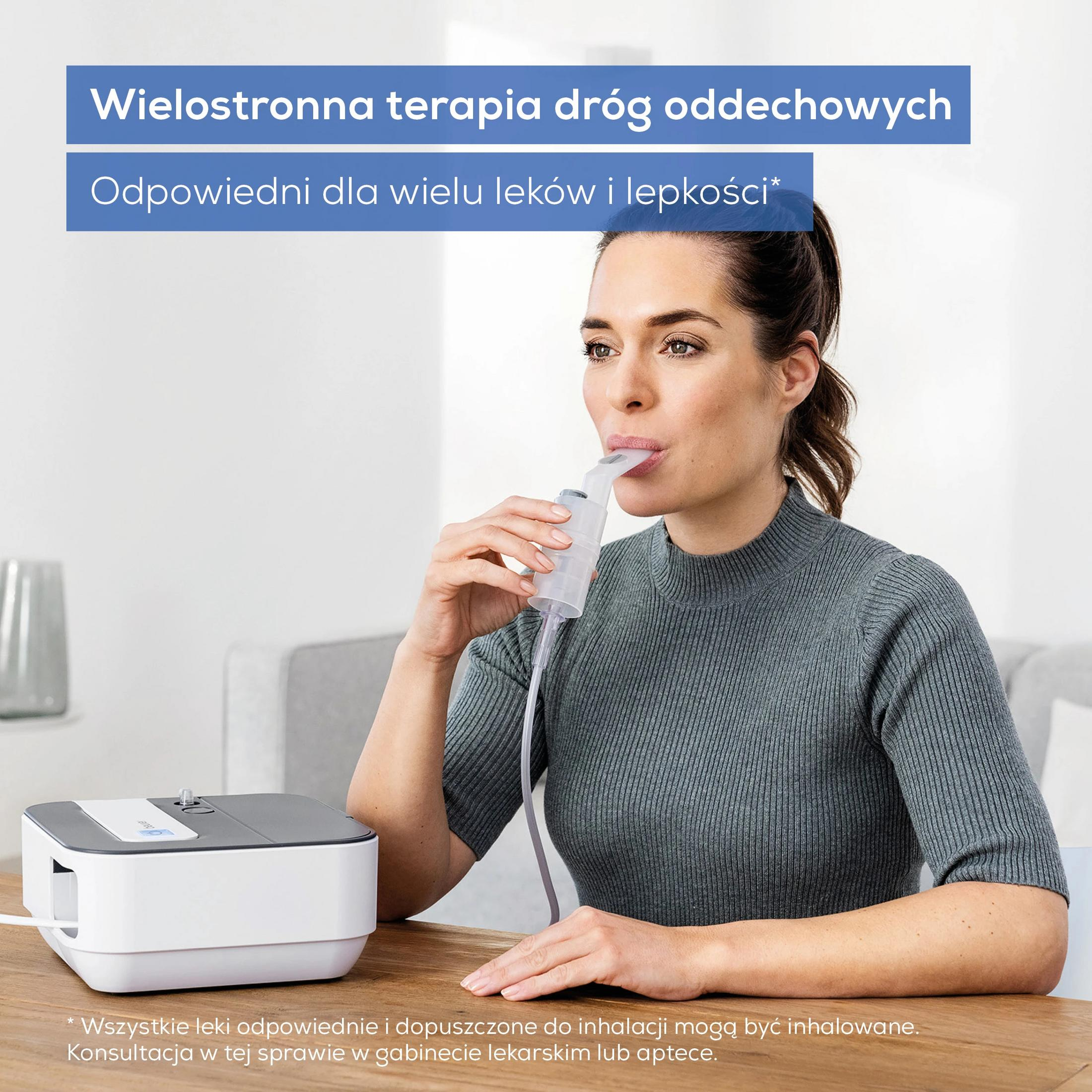 Een vrouw gebruikt een inhalator terwijl een apparaat op een tafel staat.