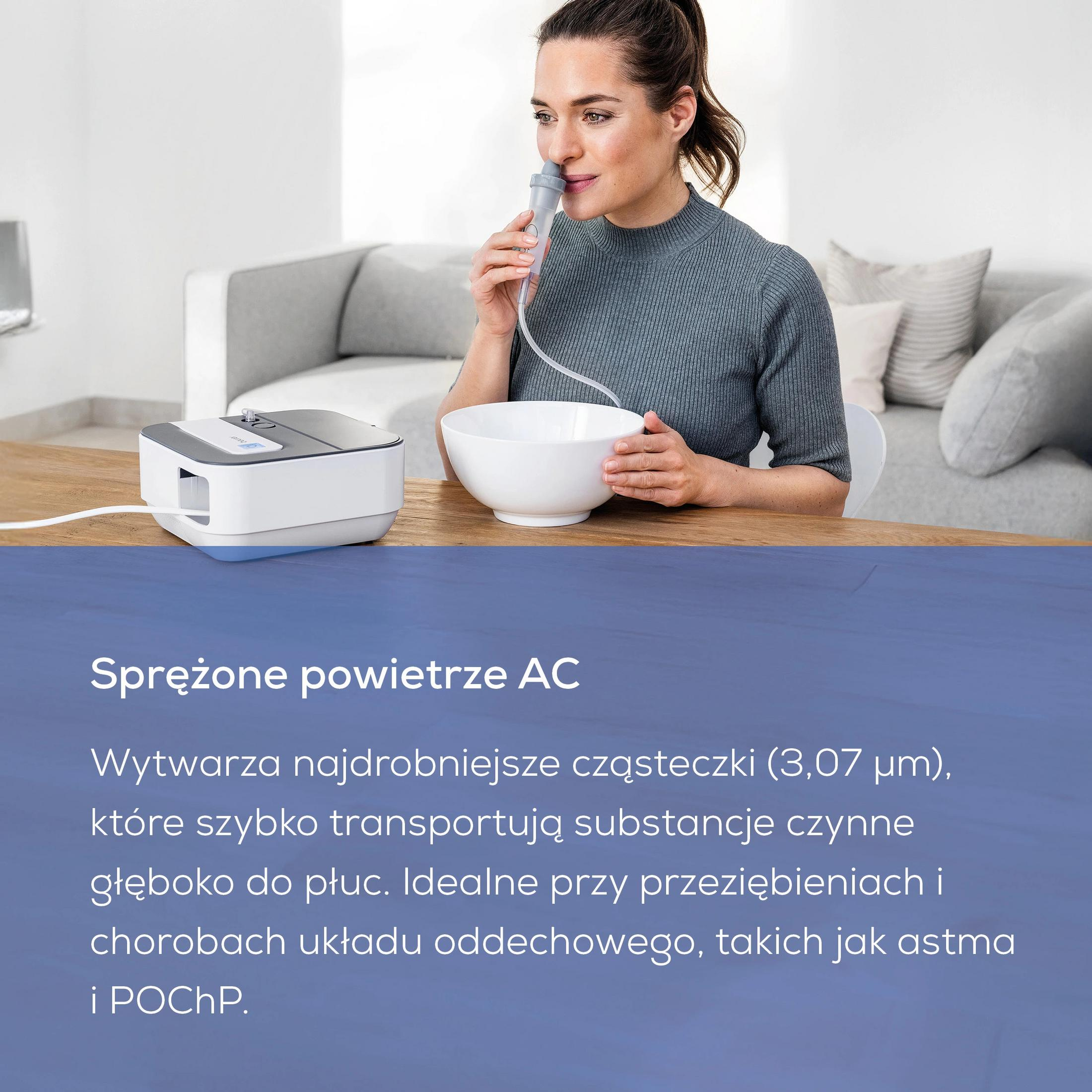 Een vrouw gebruikt een vernevelaar. Een witte vernevelaar staat op een houten tafel.