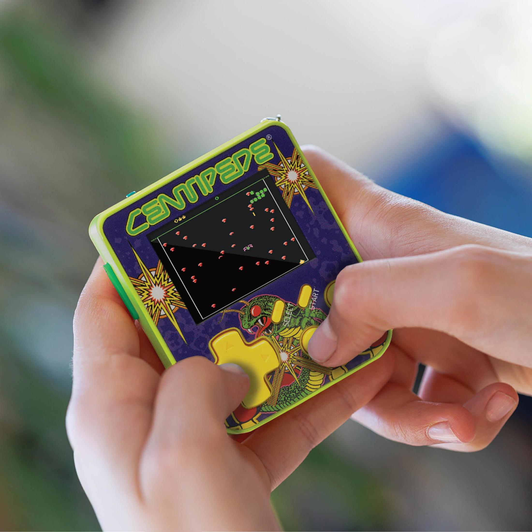 Persona juega un pequeño dispositivo de juego portátil con gráficos de Centipede.