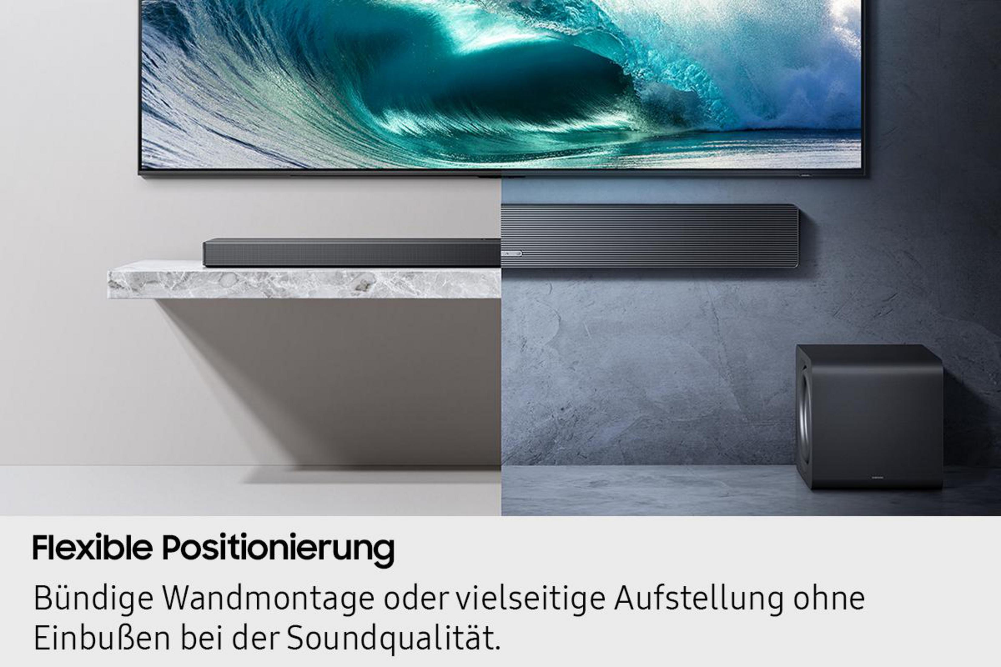 Ein TV mit Soundbar auf einem Regal und ein Subwoofer daneben.