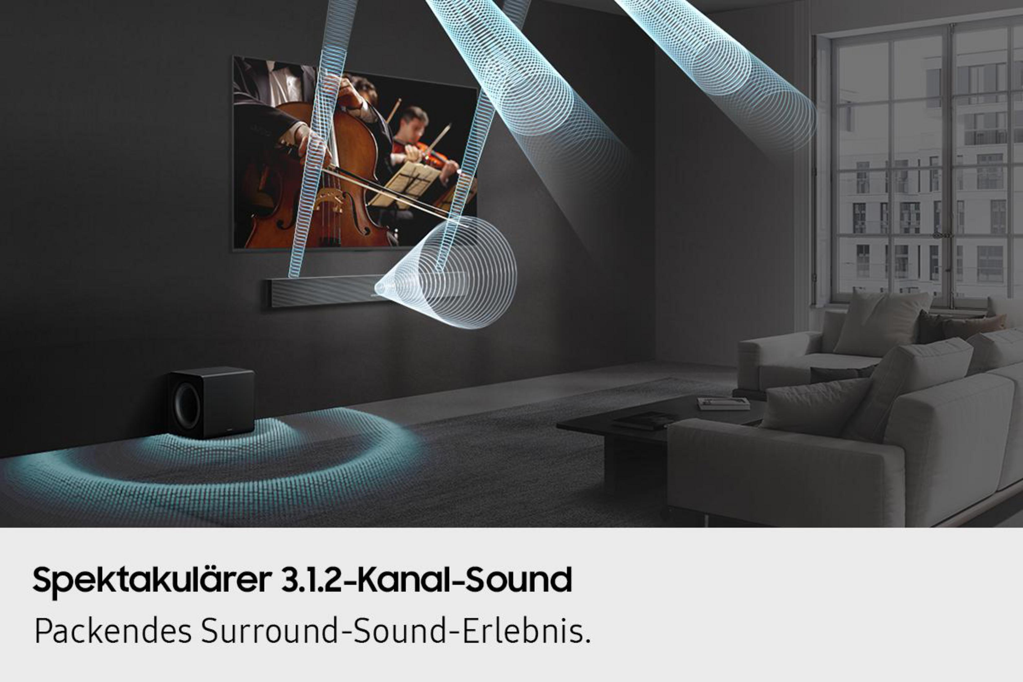 Ein schwarzer Subwoofer und eine Soundbar in einem Wohnzimmer mit Orchester auf dem Bildschirm.