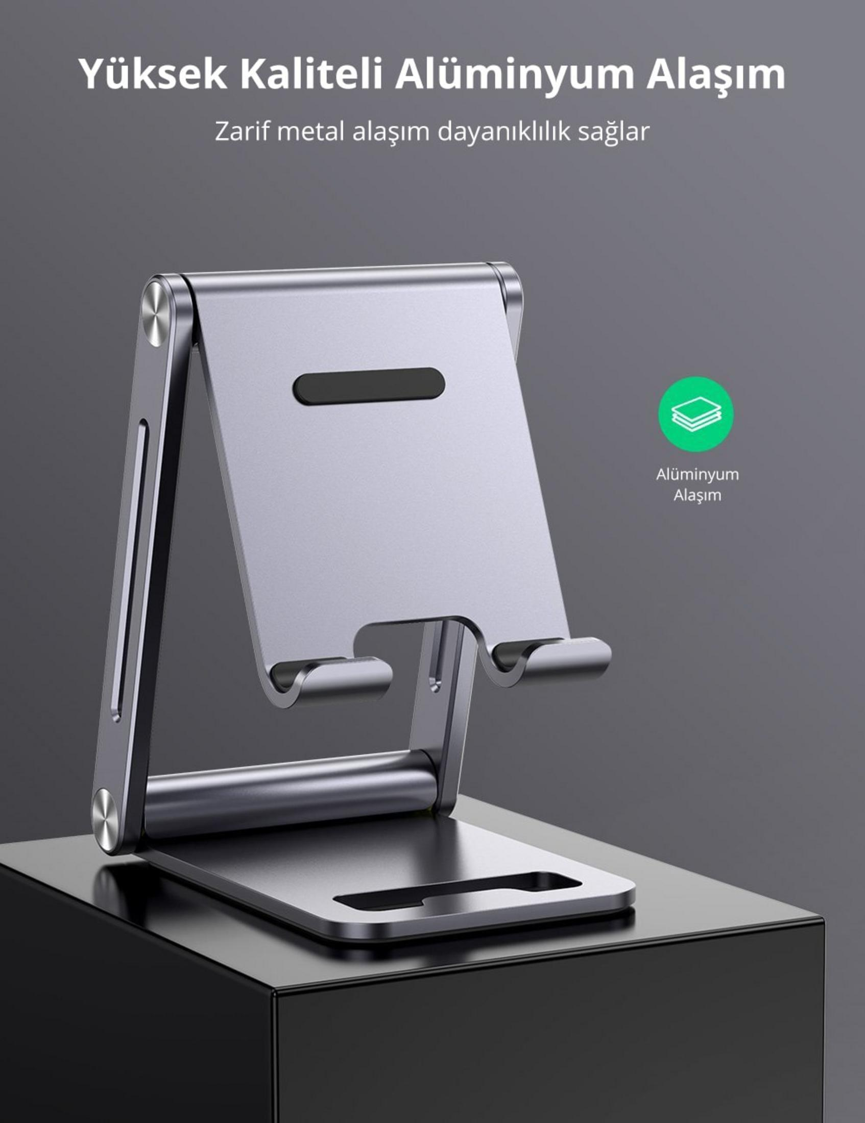 Grauer Aluminium-Ständer für Smartphones oder Tablets auf schwarzem Podest.