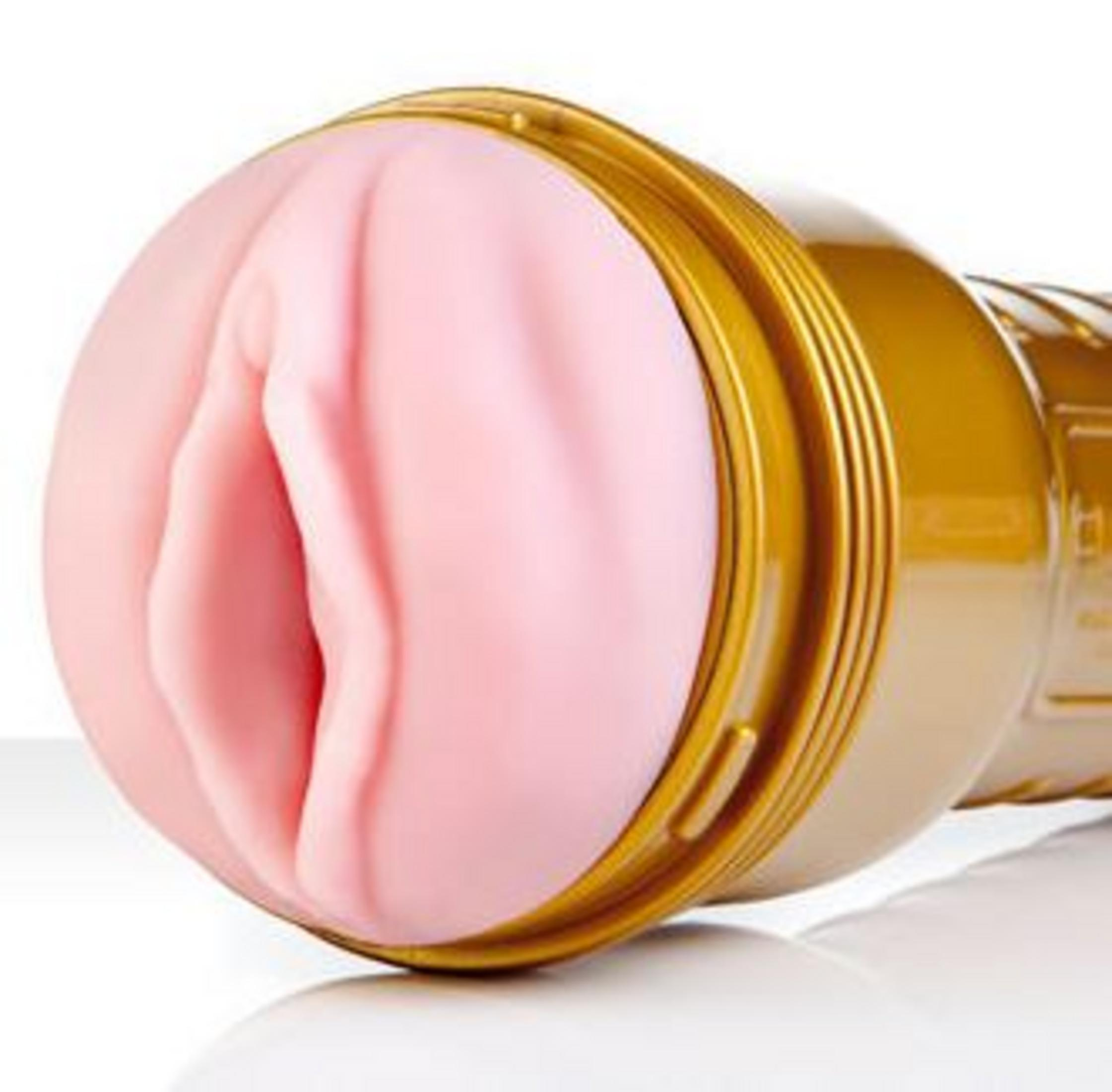 Ein goldener, zylindrischer Gegenstand mit einer rosa, texturierten Öffnung.