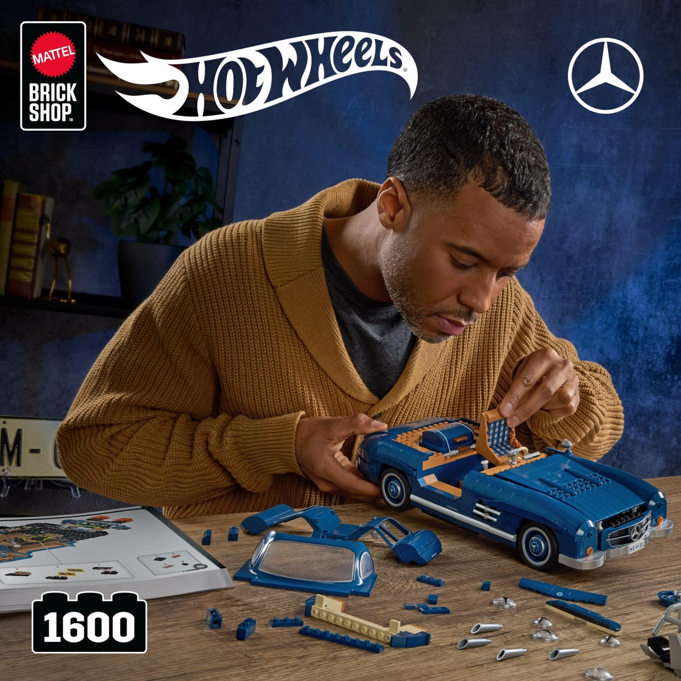 Un hombre monta un coche deportivo Mercedes Lego azul.
