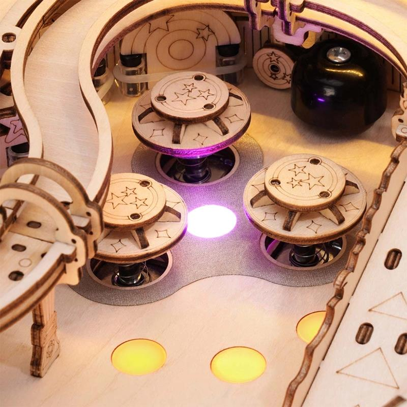 Hölzerne Flipperautomat mit Sternendetails, lila und gelben Lichtern.