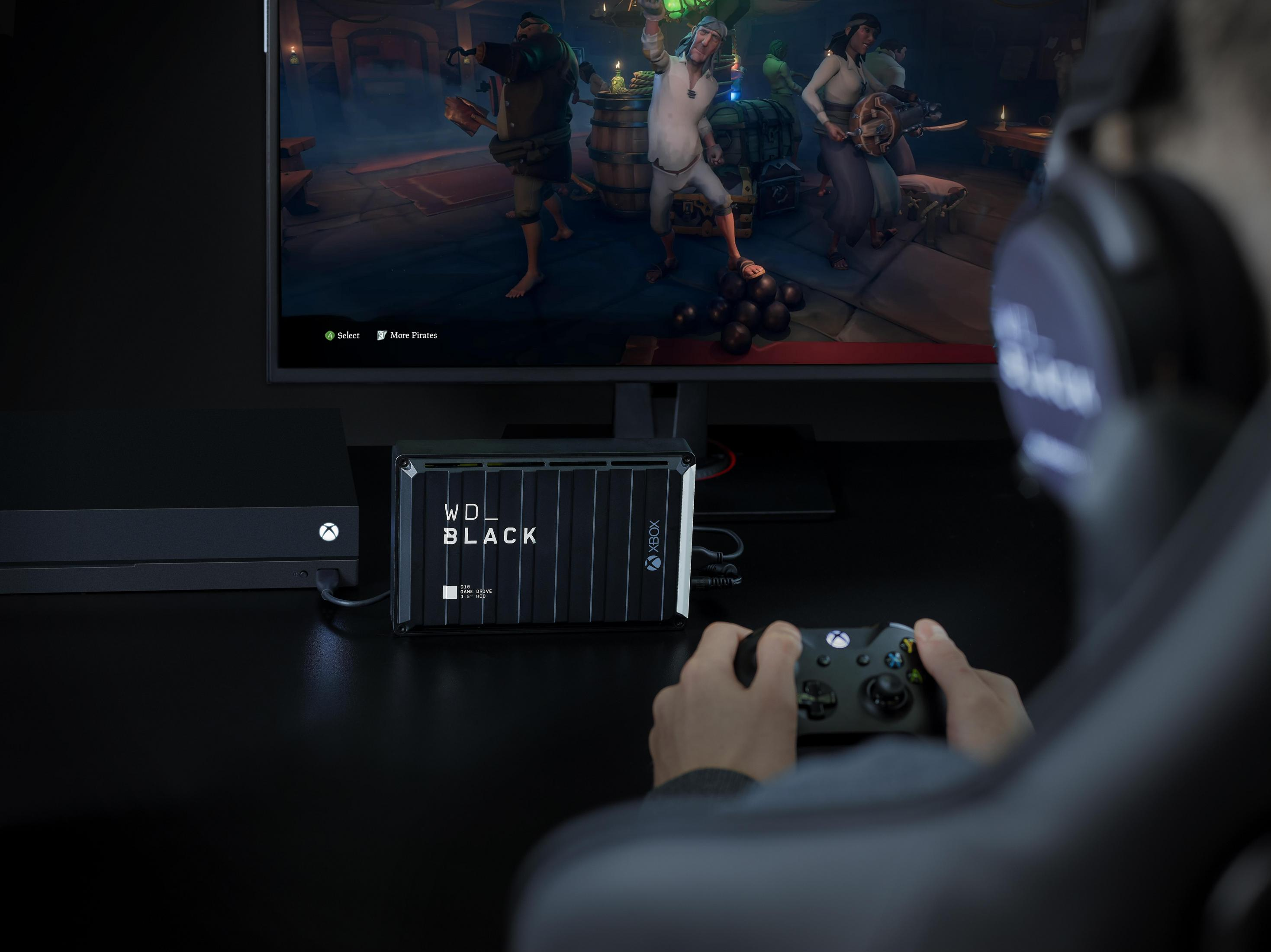 Persona gioca ai videogiochi con controller Xbox, unità WD_BLACK e console Xbox.
