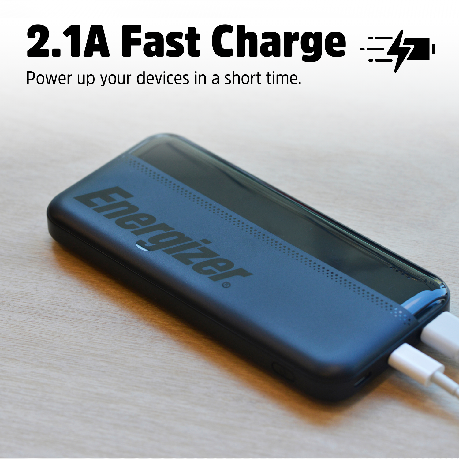 Een zwarte Energizer powerbank met twee witte kabels aangesloten.