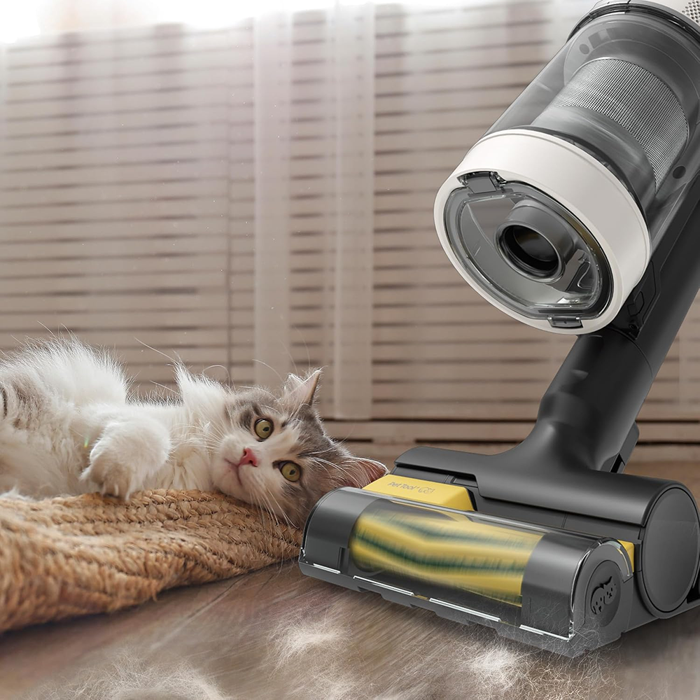 Eine Katze liegt auf einer Matte, während ein Staubsauger mit rotierender Bürste den Boden reinigt.