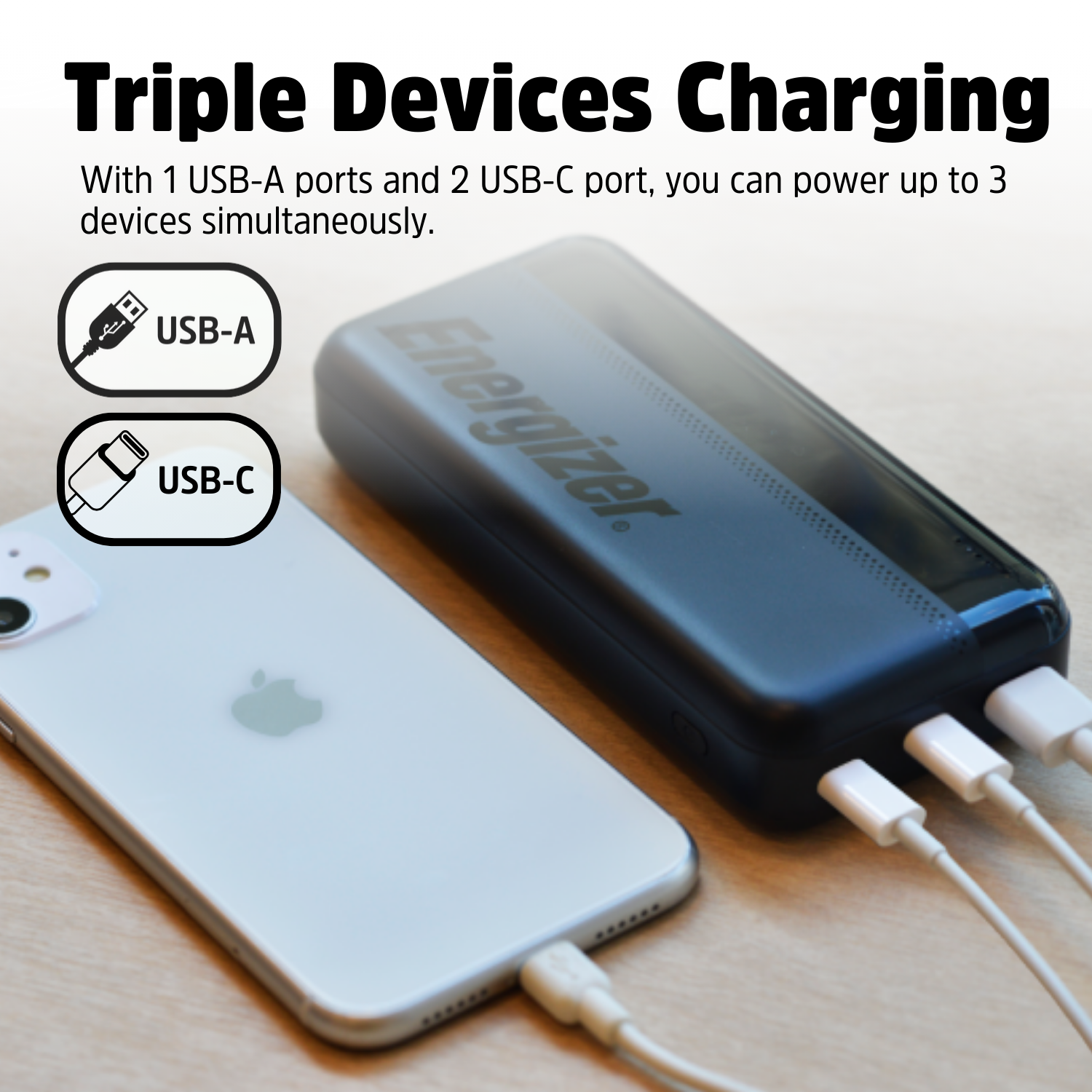 Zwarte Energizer powerbank laadt een witte iPhone op met drie USB-kabels.