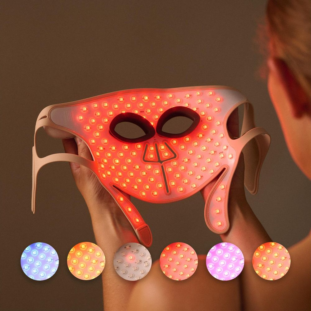 Una persona tiene una maschera per il viso a LED rossi, con sei cerchi colorati sotto.
