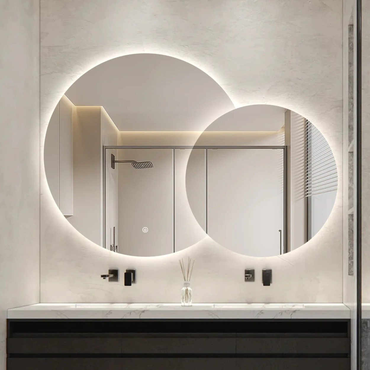 Moderne badkamer met twee verlichte ronde spiegels boven een marmeren ijdelheid.