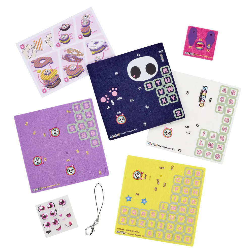 Widok z góry akcesoriów Stackables Pop Girl Phoebe: naklejki, arkusze cyfr/liter, instrukcje.