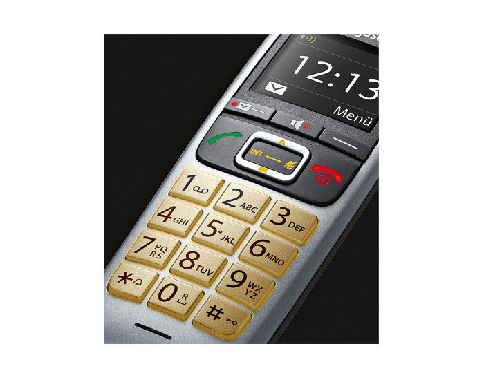 Primo piano di un telefono argentato con tastiera dorata e schermo che mostra le 12:13.