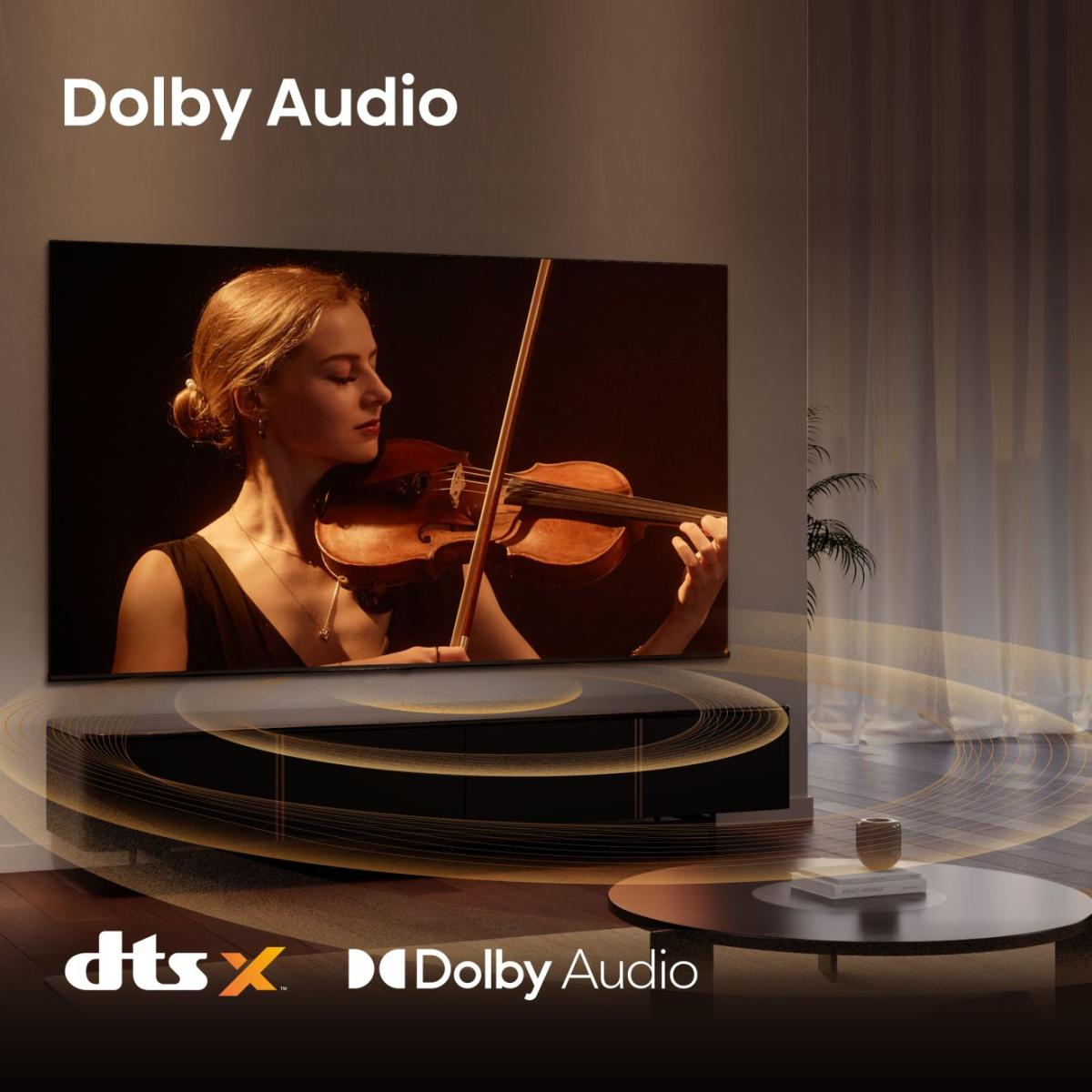 Eine Frau spielt Geige auf einem Fernsehbildschirm. Dolby Audio & DTS:X Logos.