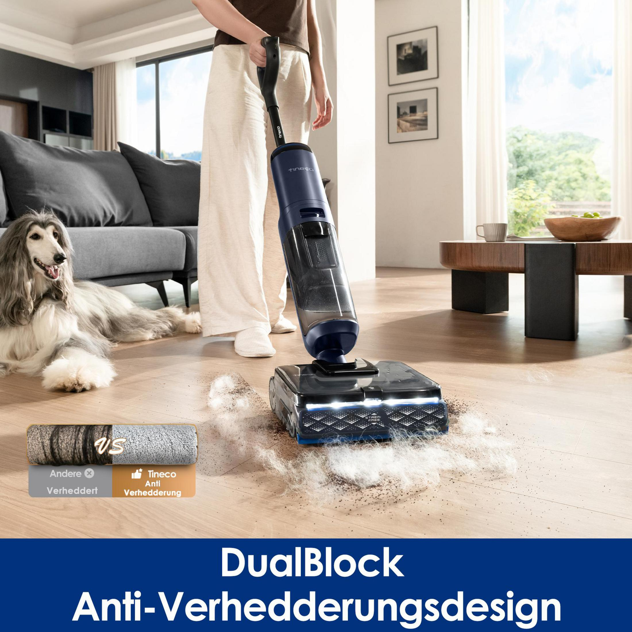 Ein Hund liegt auf dem Boden, während ein Staubsauger Schmutz aufsaugt.