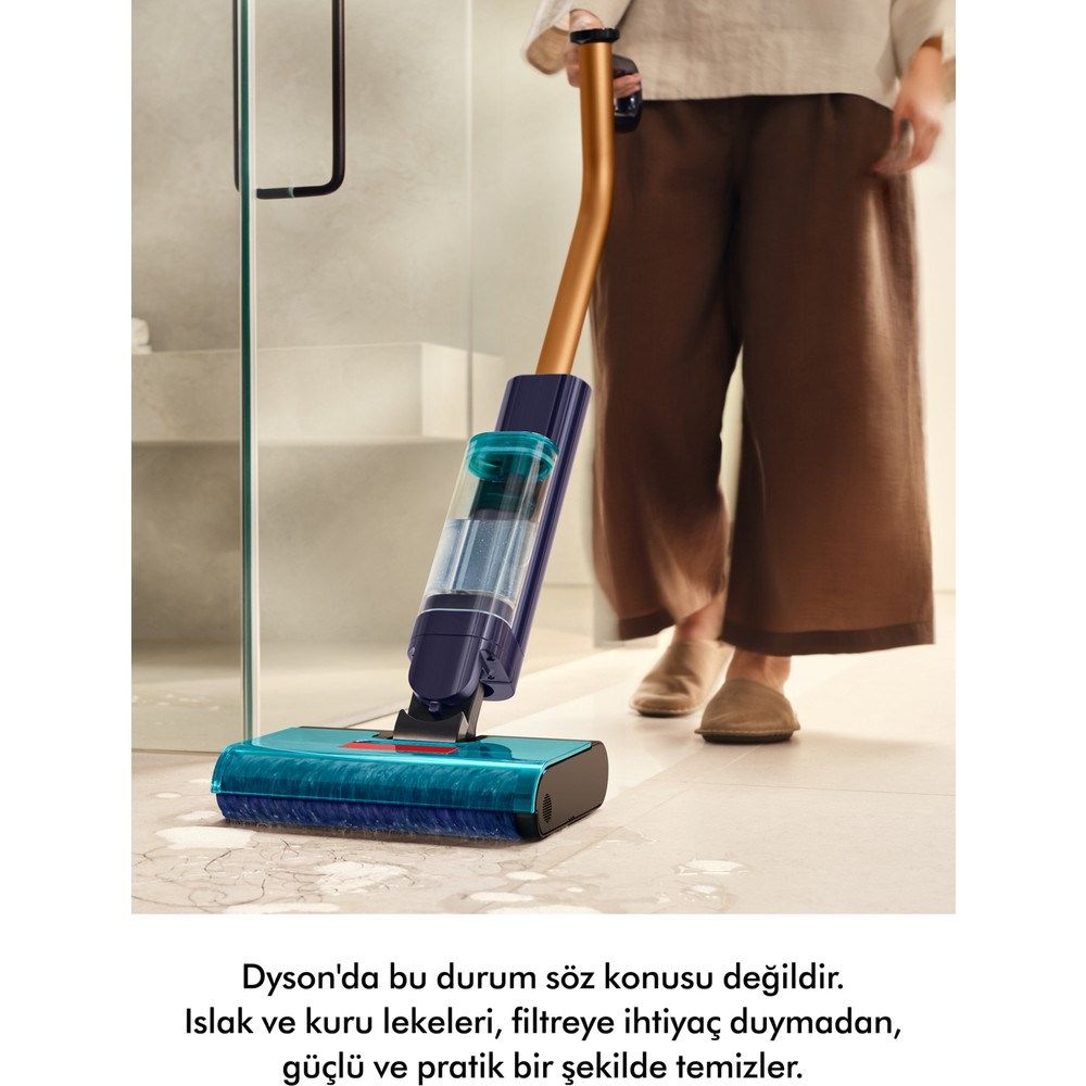 Persona pulisce macchia bagnata sul pavimento con aspirapolvere blu e blu scuro.