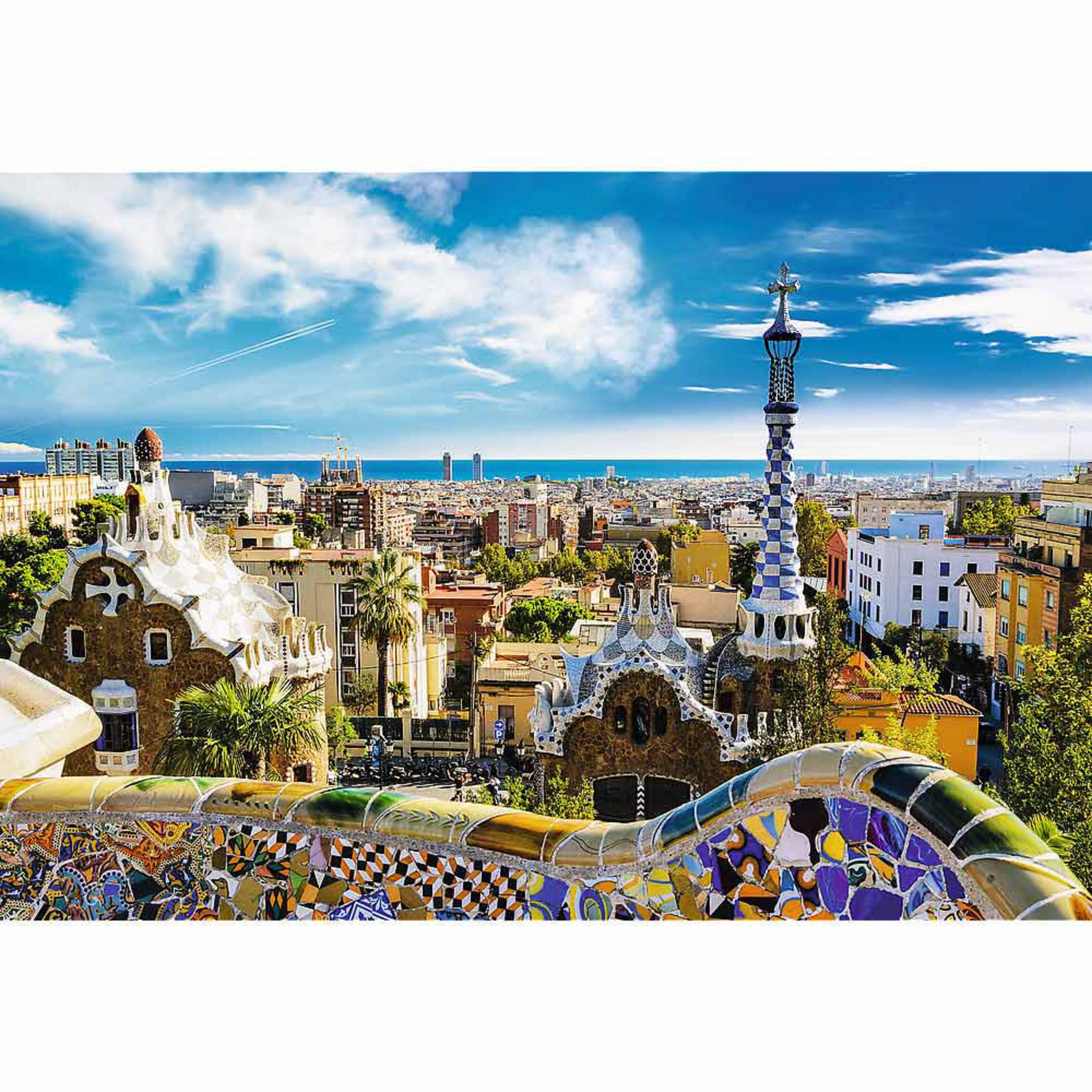 Parque Güell en Barcelona con mosaicos coloridos y horizonte urbano junto al mar.