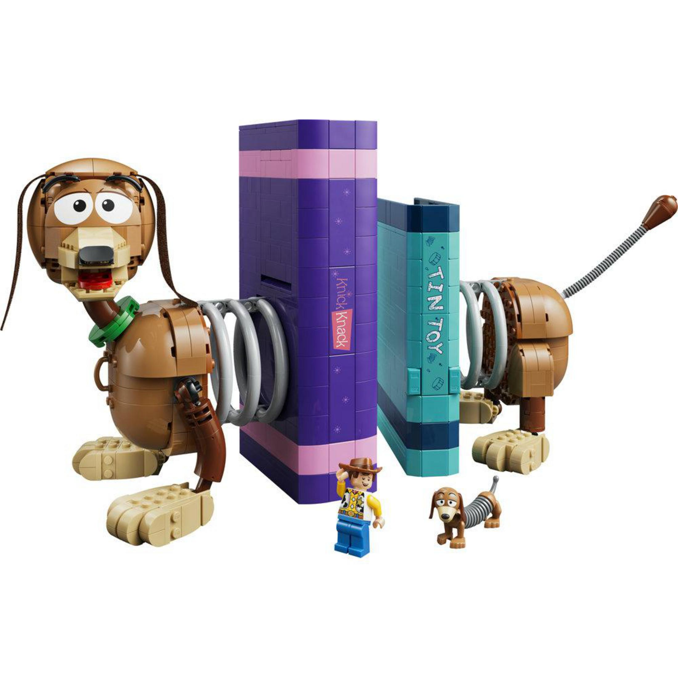 LEGO Slinky Dog z Woodym i małym psem, obok dwóch książek.
