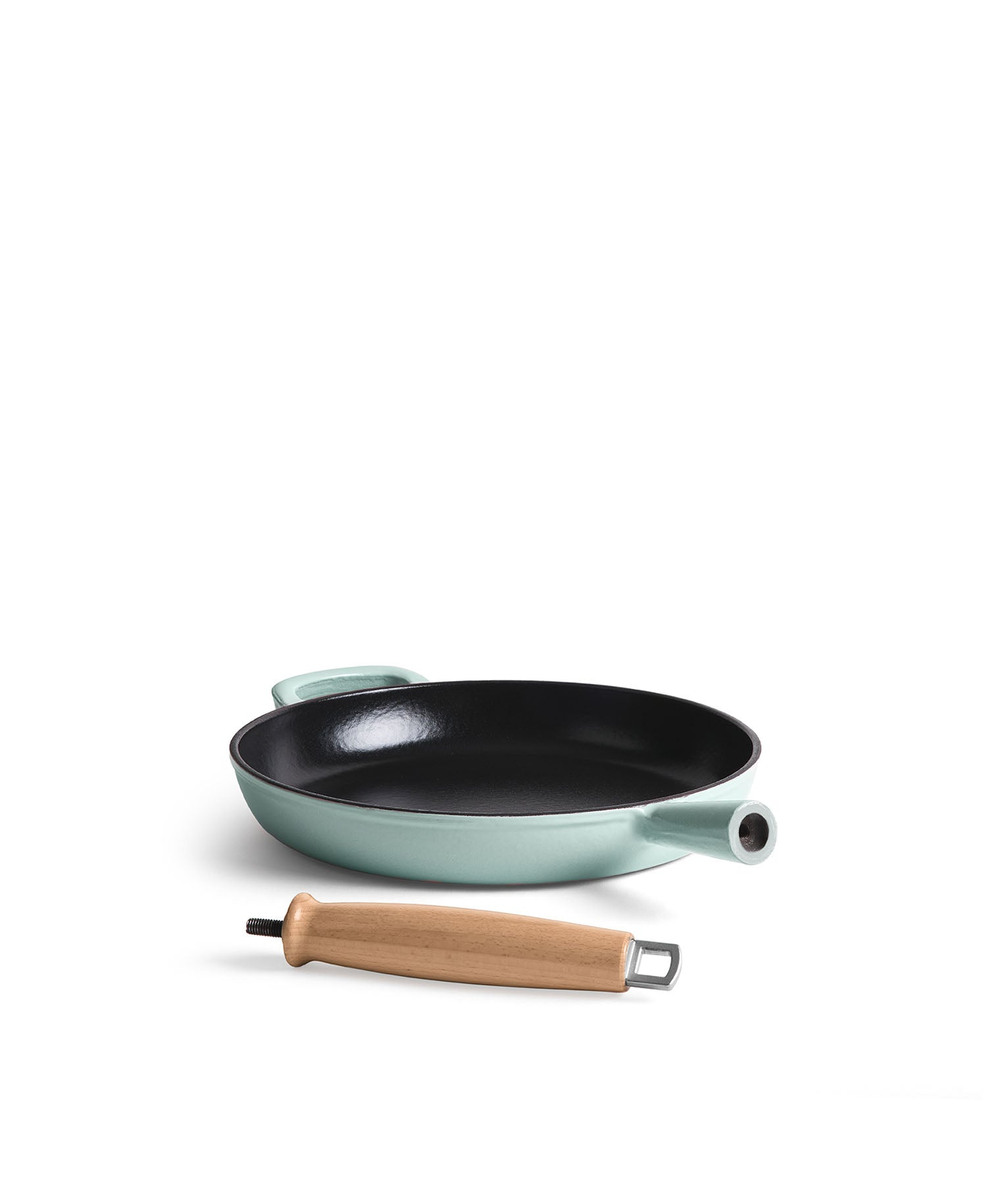 Una sartén verde claro con interior negro y un mango de madera al lado.