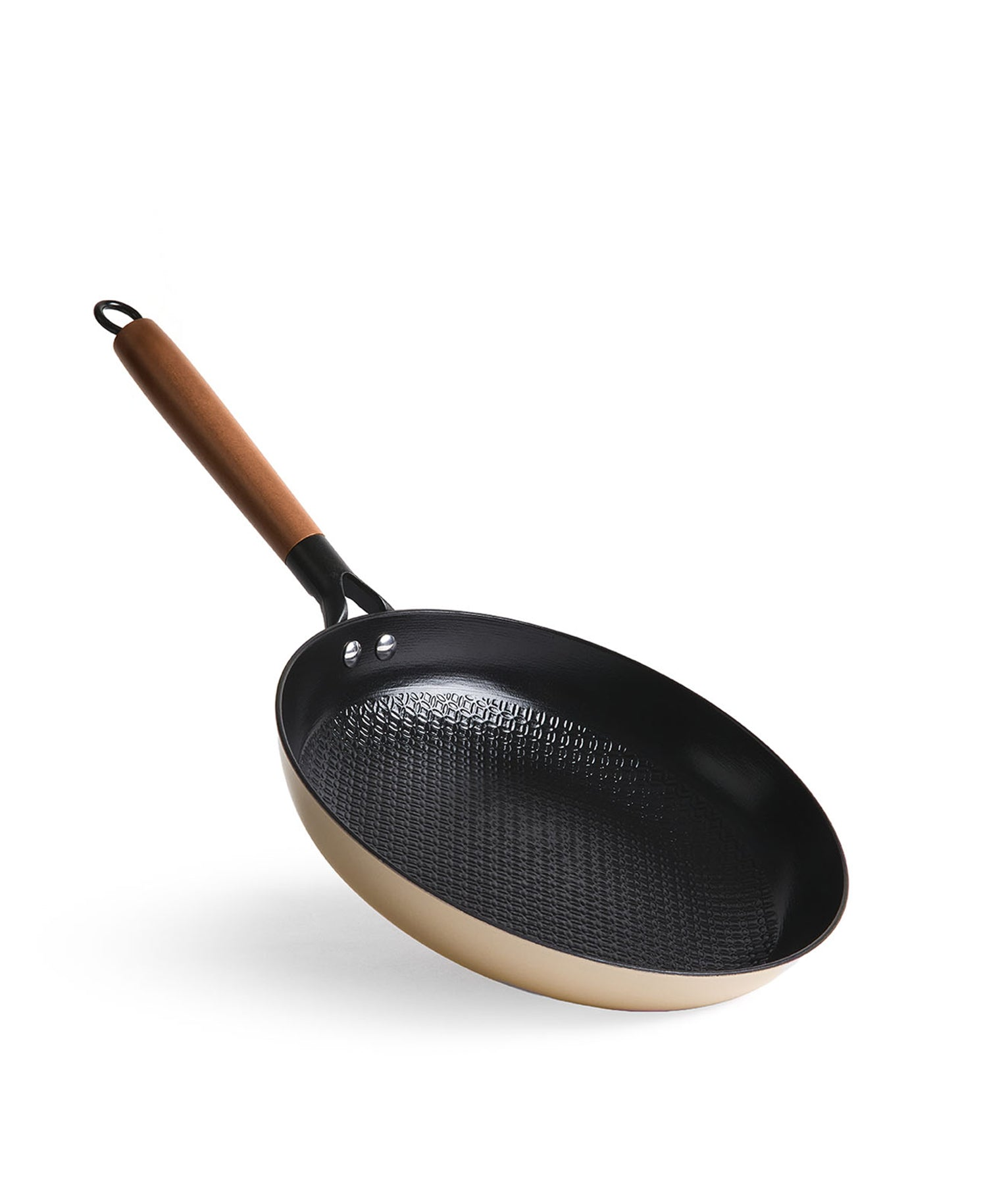 Una sartén dorada con mango de madera y interior negro texturizado.