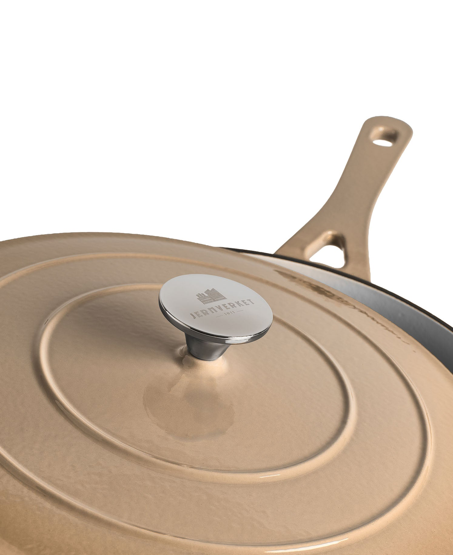Una olla de hierro fundido beige con asa plateada y logo en la tapa.