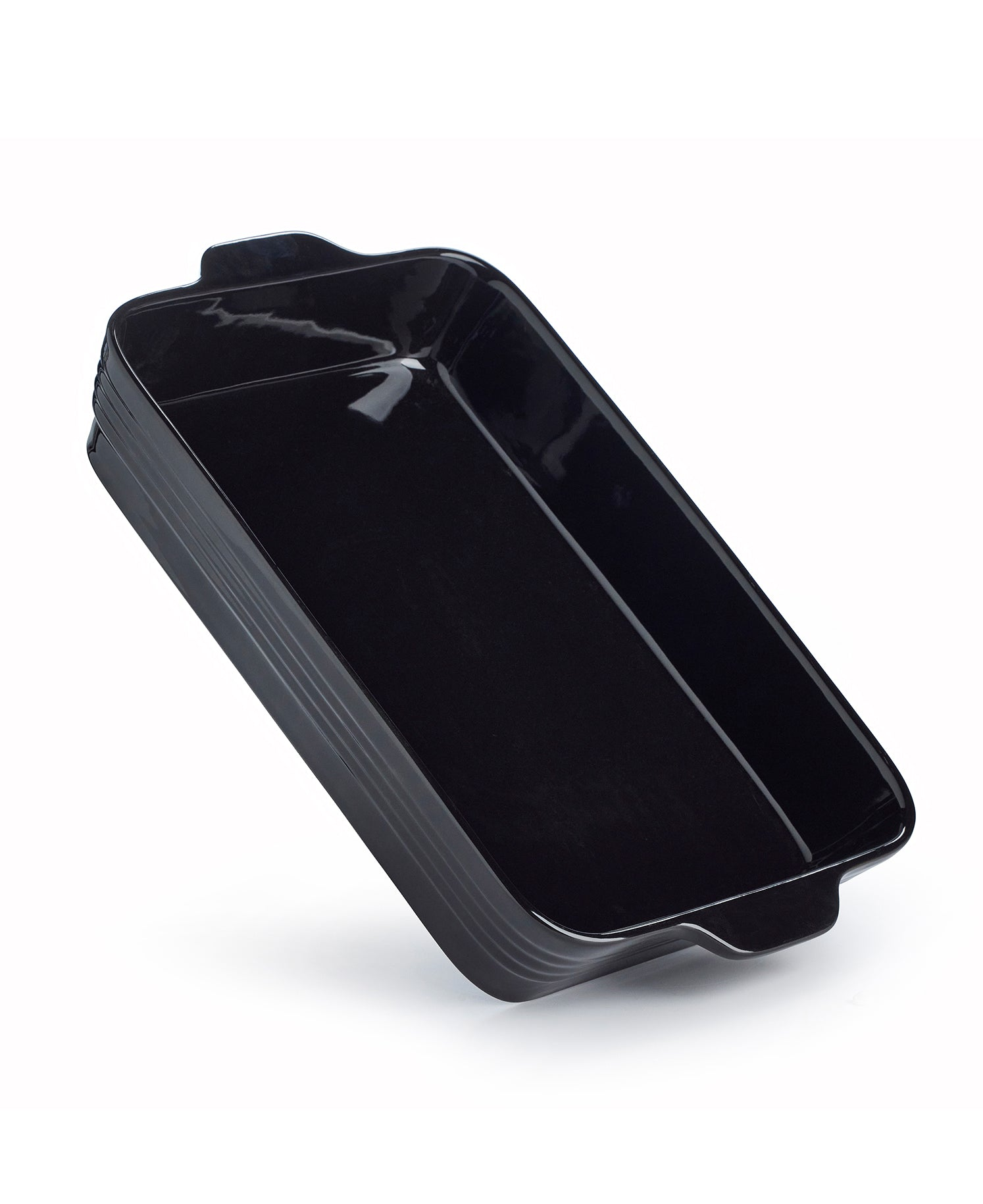 Una fuente de horno rectangular negra con asas sobre fondo blanco.