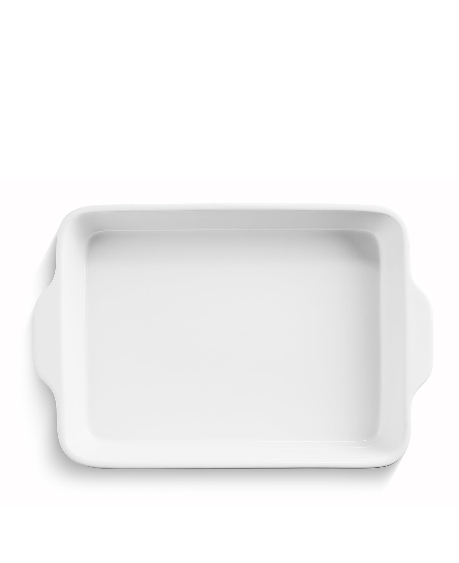 Una fuente rectangular blanca para hornear con asas sobre fondo blanco.