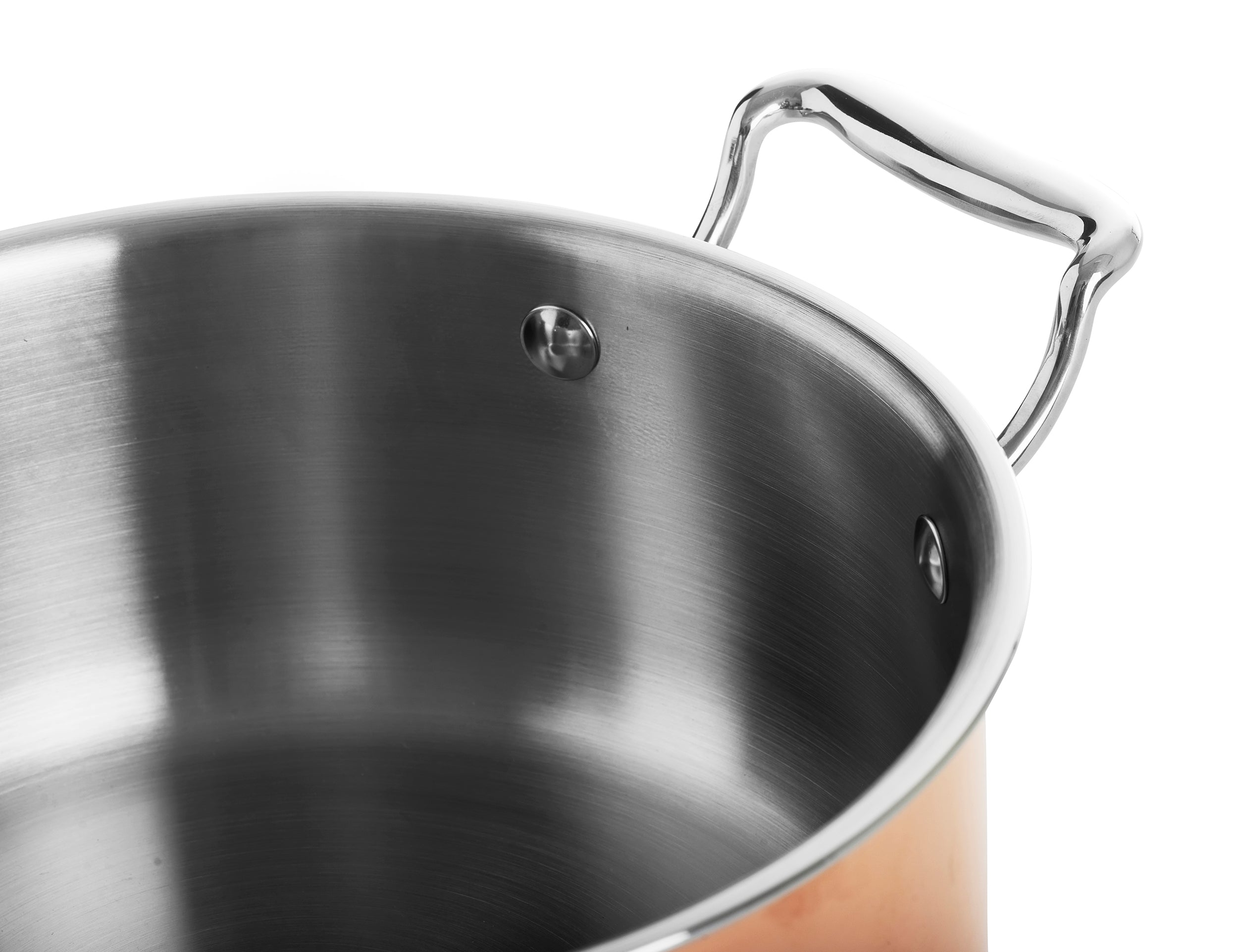 Primer plano de una olla de cobre brillante con interior y asa de acero inoxidable.