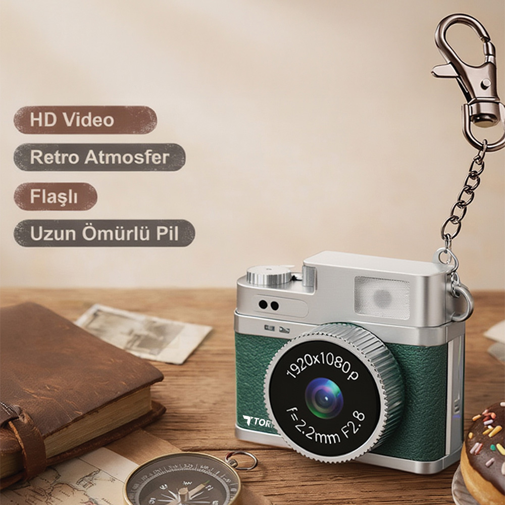 Anahtarlıklı retro tarzı yeşil kamera, yanında defter ve pusula.