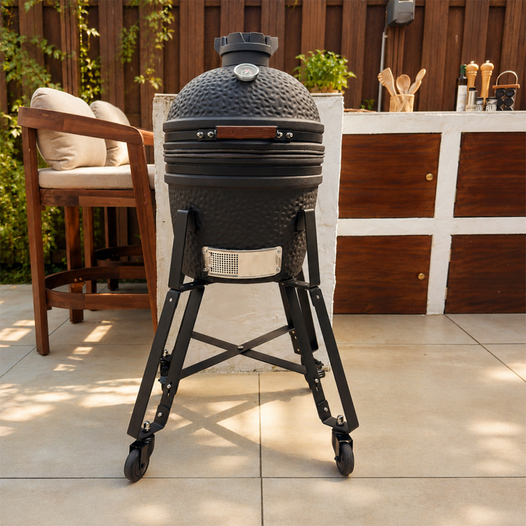 Ein schwarzer Keramikgrill mit Thermometer steht auf einem Metallgestell mit Rädern.