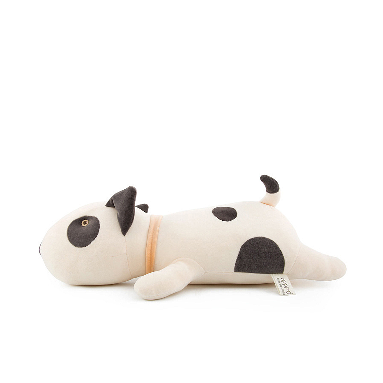 Un cane di peluche beige con macchie scure giace su un fianco.