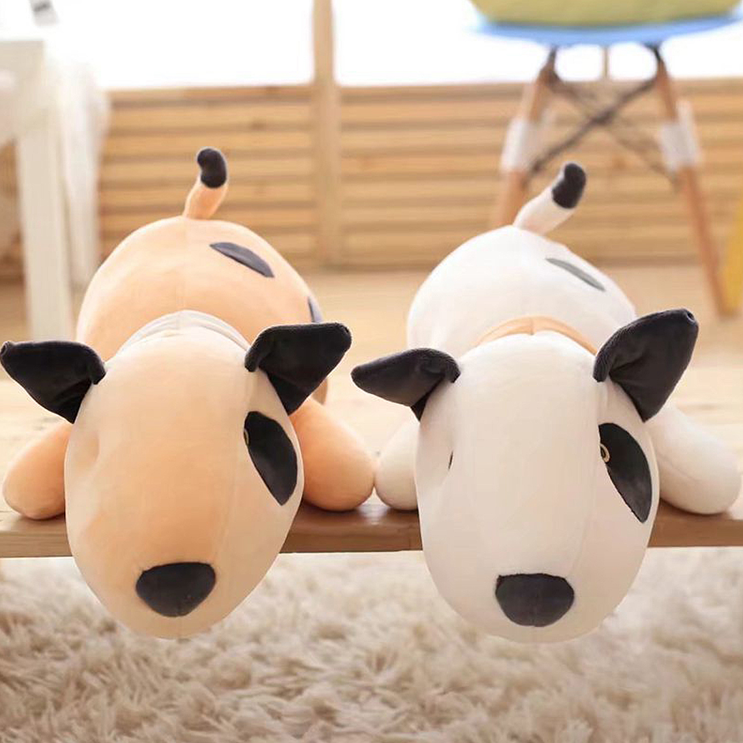 Due cani bull terrier di peluche giacciono uno accanto all'altro.