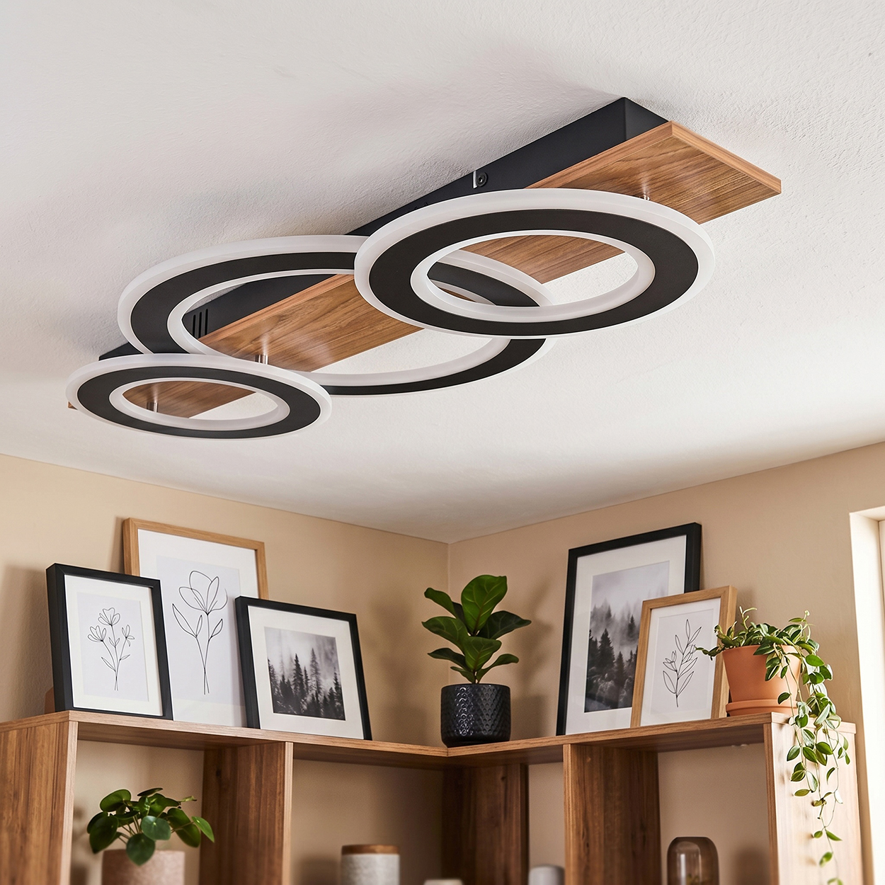 Moderne Deckenleuchte mit Holzplatte und schwarzen Ringen mit LED-Beleuchtung.