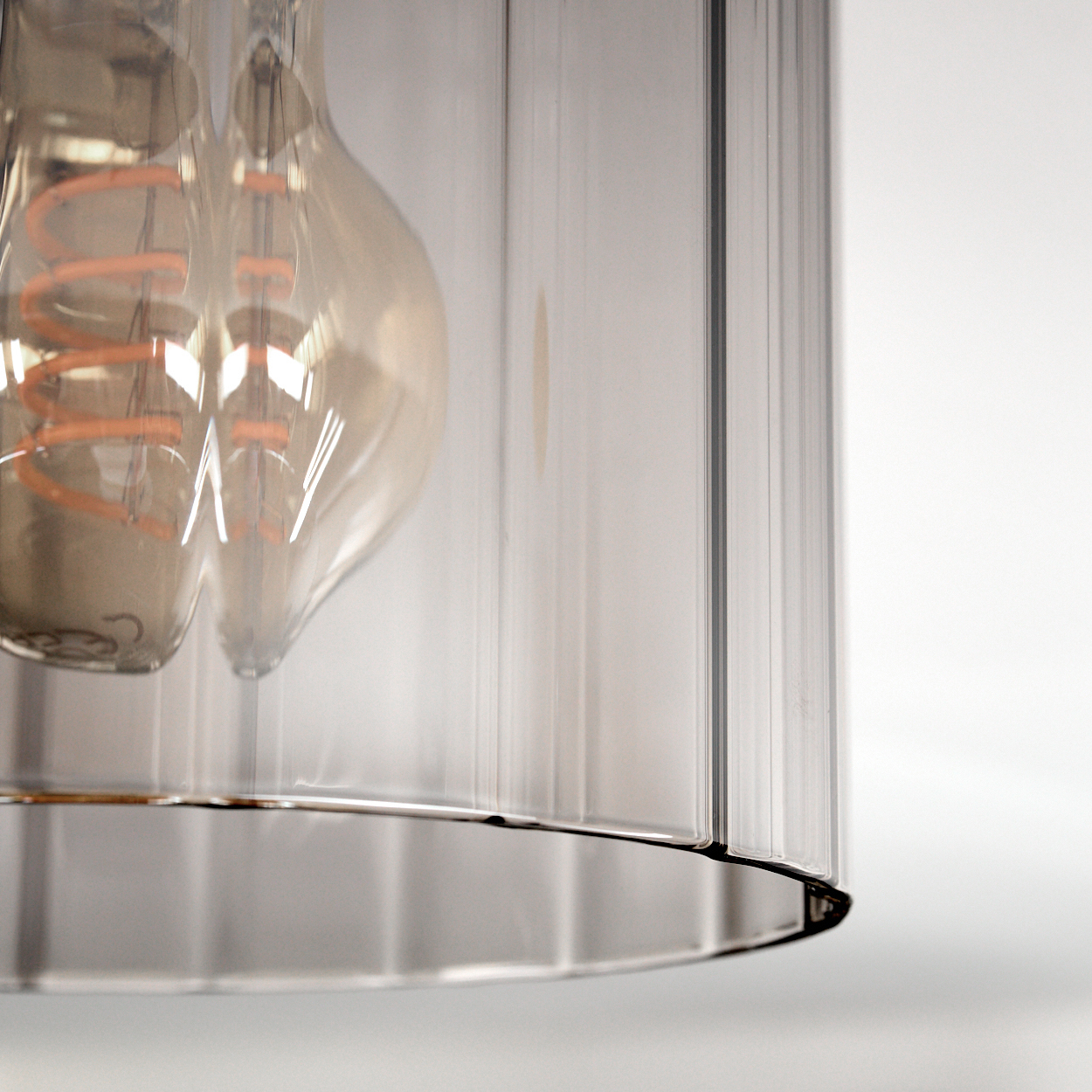 Glühbirne mit Spiralwendel in Glaszylinder auf weißem Hintergrund.