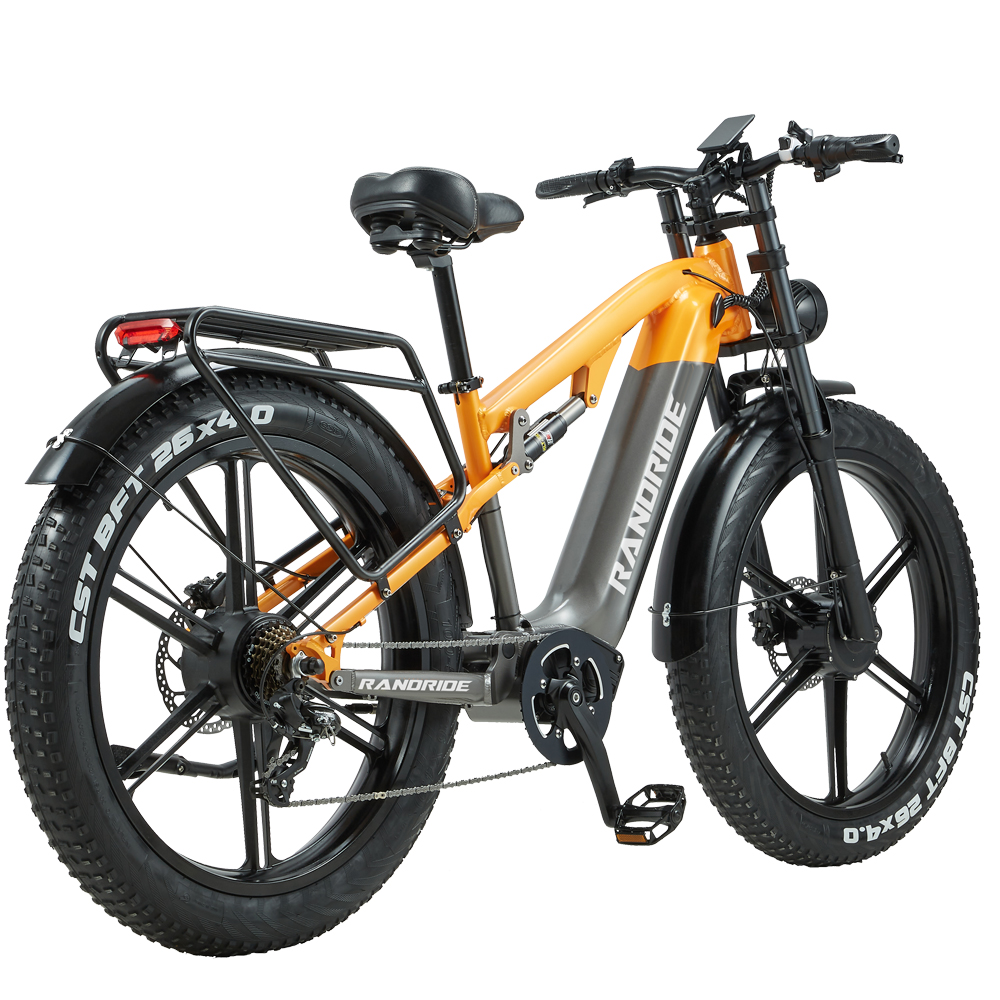 Ein orangefarbenes und graues E-Bike mit dicken Reifen und Gepäckträger.
