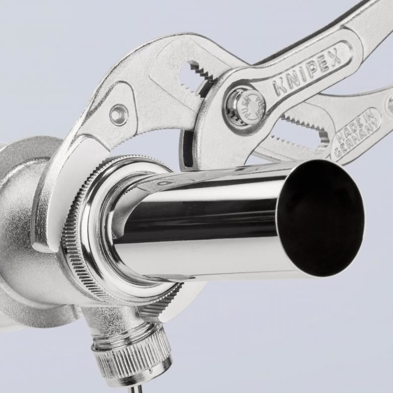 Una pinza Knipex plateada sujeta una tubería metálica brillante. Made in Germany.