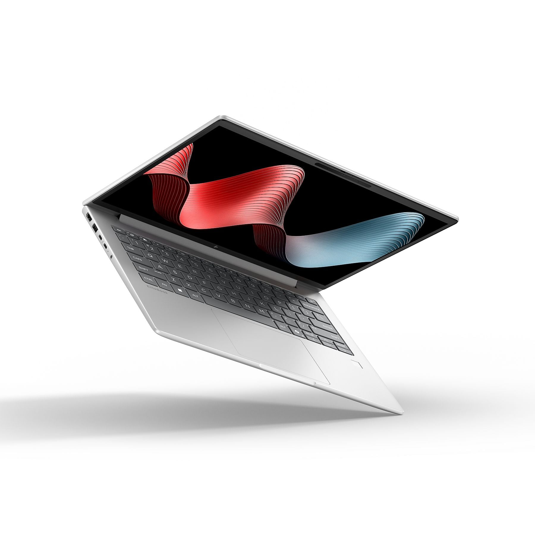 Un laptop argentato con lo schermo aperto, che mostra uno sfondo astratto di onde rosse e blu.