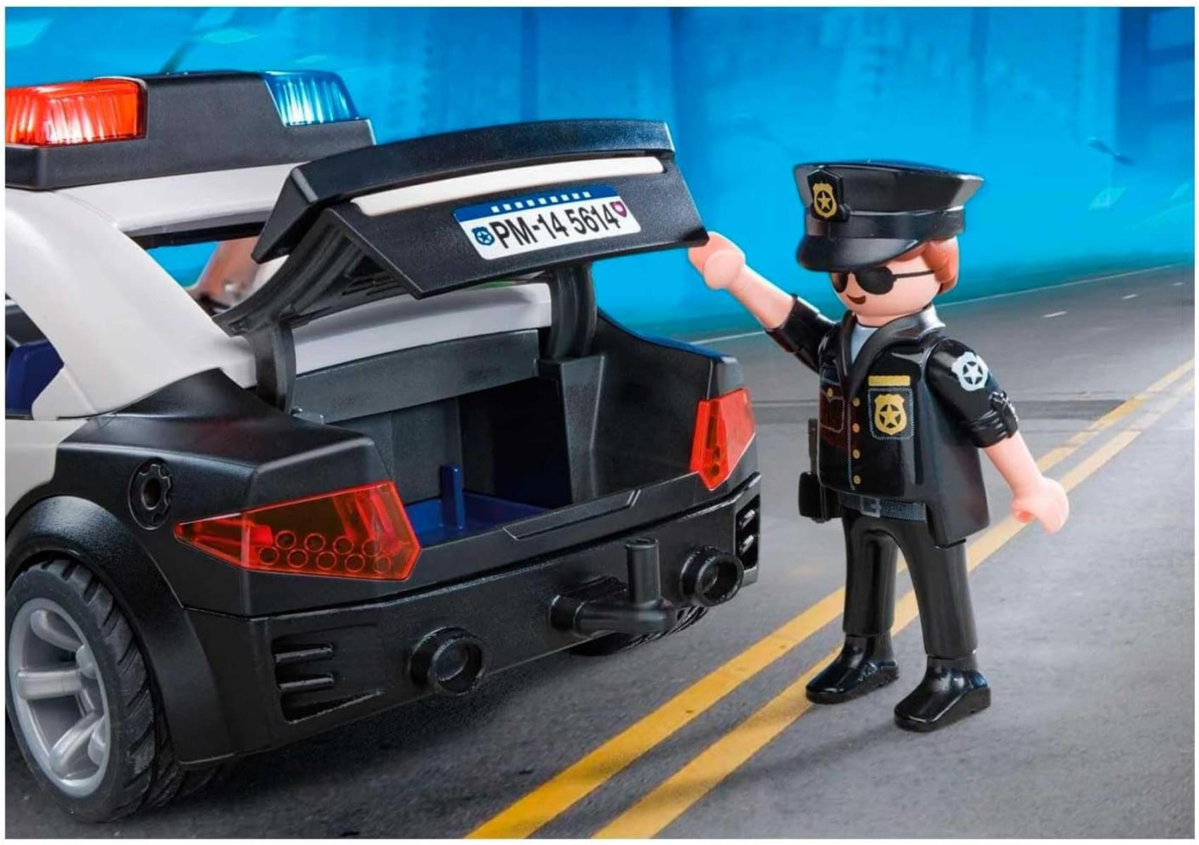 Un policía de Playmobil cierra el maletero de un coche patrulla con luces intermitentes.