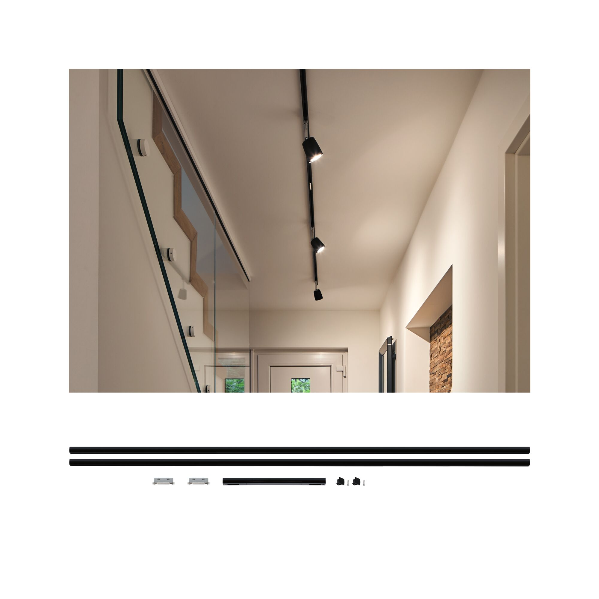 Ein Flur mit Treppe, Glasgeländer und Schienensystem mit Spots an der Decke.