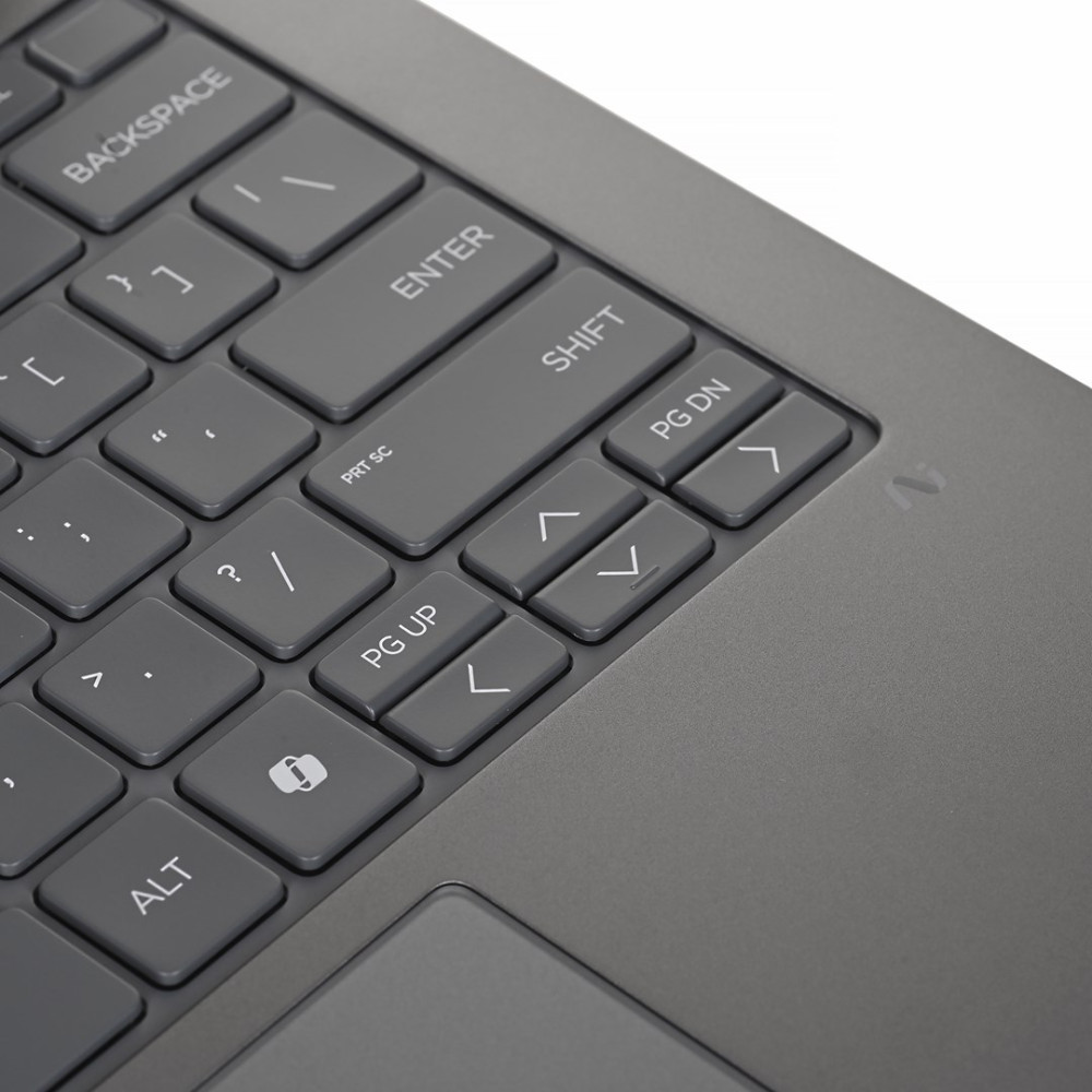 Zbliżenie szarej klawiatury laptopa z klawiszami Shift, Enter i strzałkami.