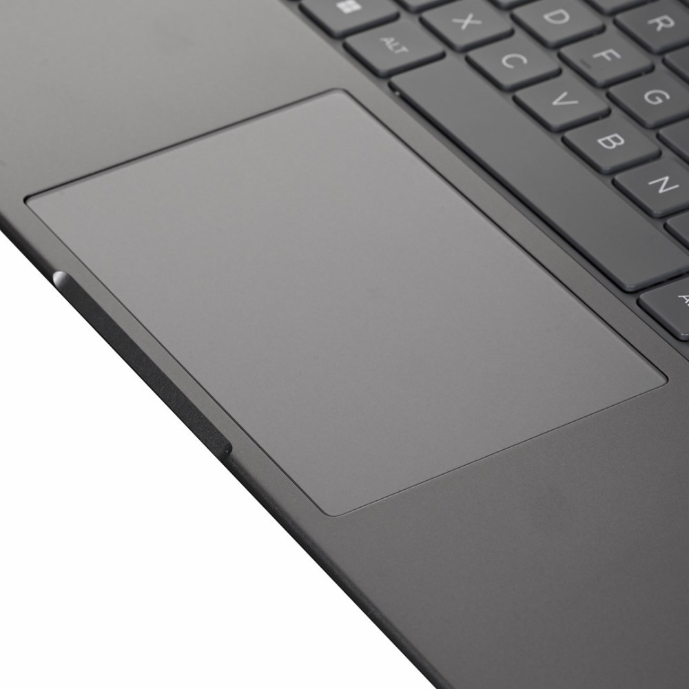 Szary touchpad i klawiatura laptopa z czarnymi klawiszami, zbliżenie.